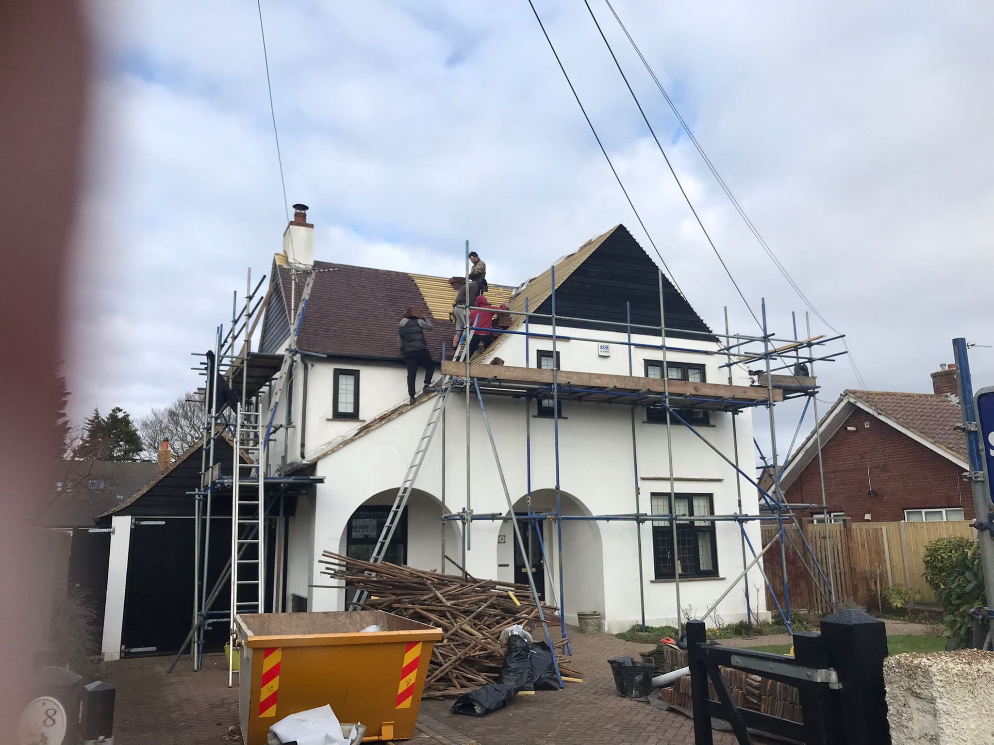 Scaffolding up round a white rendered house in Kent while its fascias are repaired
