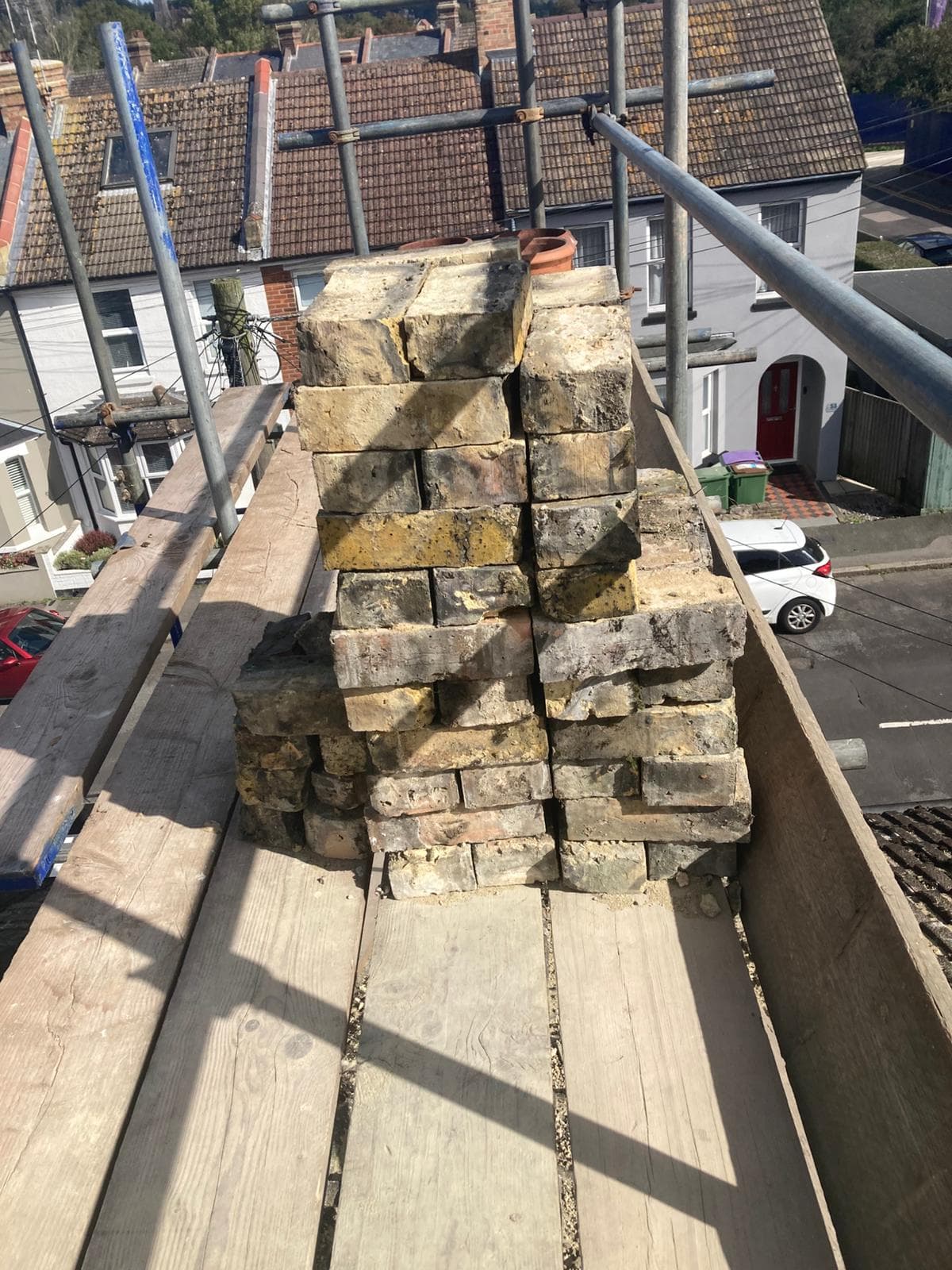 Yellow stock bricks stacked on the scaffold above a terraced street