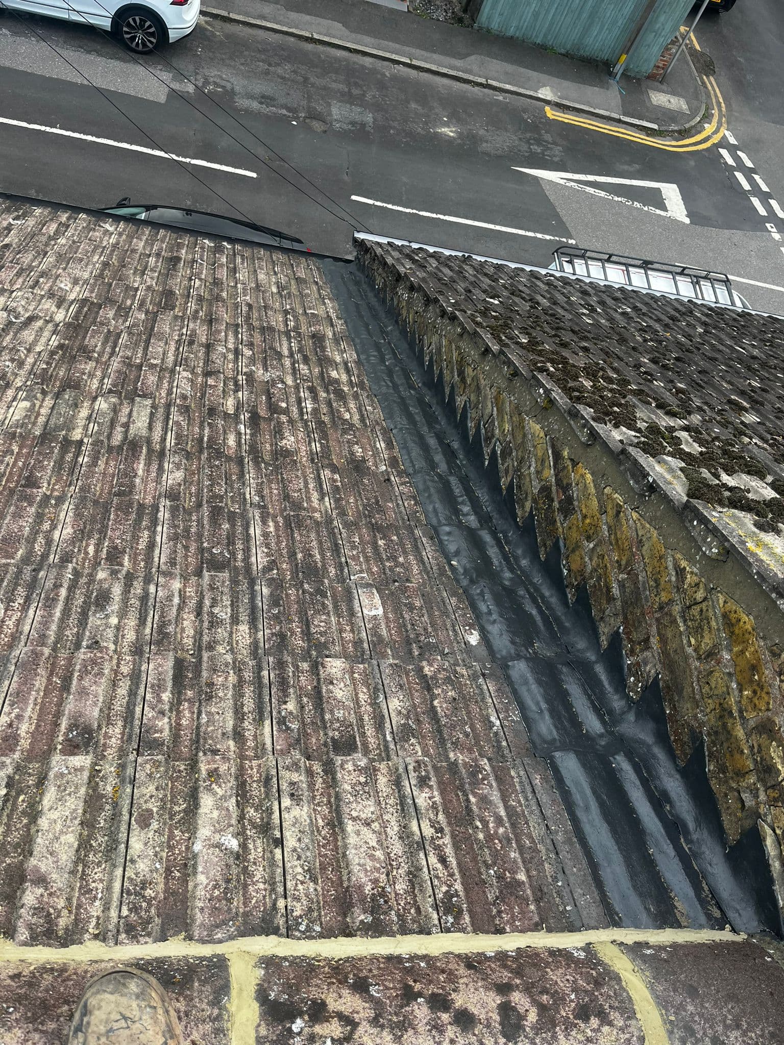 A valley between two concrete tiled slopes, lined in black, above the street